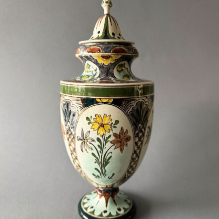 Rozenburg Den Haag, urnvormige vaas met deksel, model 242 uit 1894. De vaas is 30 cm hoog en 11,5 cm breed, beschilder door Willem Hartgring.