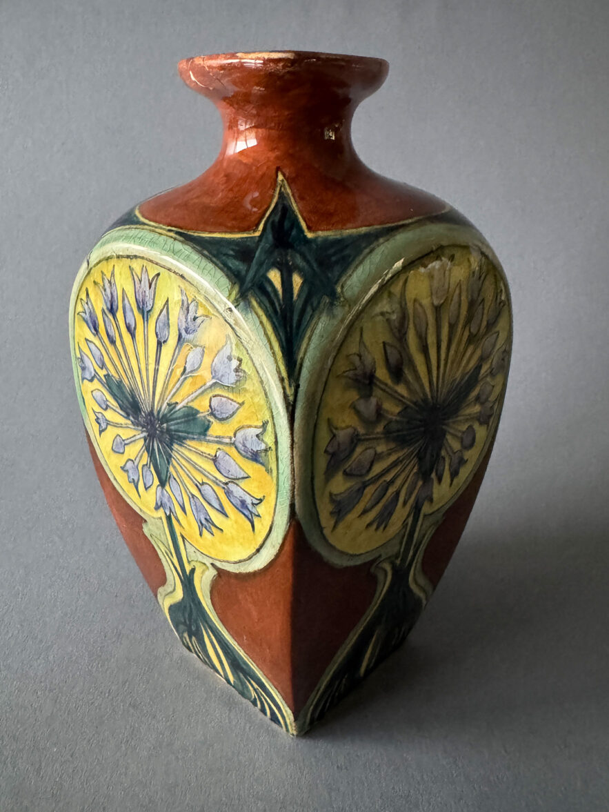 Kan van Rozenburg Den Haag, model 394 van 19,5 cm hoog, beschilderd met een decor van Zwanenbloem. De kan is gemaakt in november 1896.