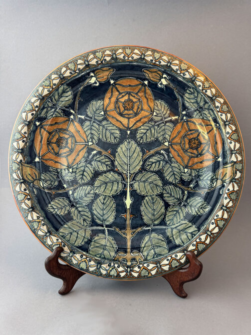 Wandschotel van Holland Utrecht of Mijnlieff met een omtrek van 44 cm en een decor van rode wilde rozen tegen een donkerblauwe achtergrond, gemaakt in de periode 1895-1904.