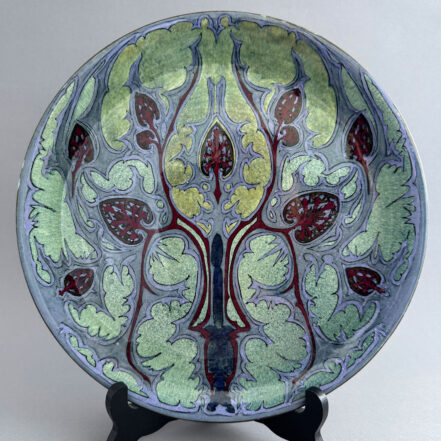 Holland Utrecht wandbord van bijna 30 cm breed met een abstract floraal decor in lila en groen, gemaakt tussen 1895-1904.
