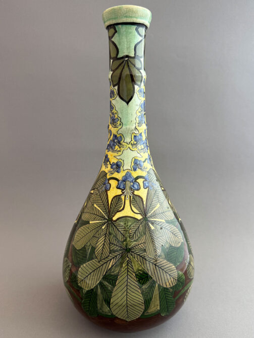 Vaas van Wed. N.S.A. Brantjes & Co uit Purmerend, 1895-1904. Model 1055, hoge flesvormige vaas van 40 cm met een decor van kastanjes.