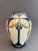 Vaas van DKP, de Dordtsche Kunstpotterij uit Dordrecht, gemaakt tussen 1903 en 1908. Dit is model 26, beschilderd met een geometrisch decor in blauw en geel, tegen een witte achtergrond.